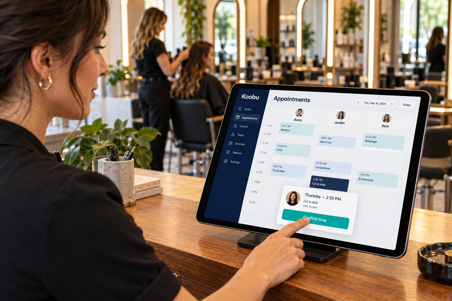 Salon owner uses an iPad at reception to review a stylist calendar while a client checks an offered time.